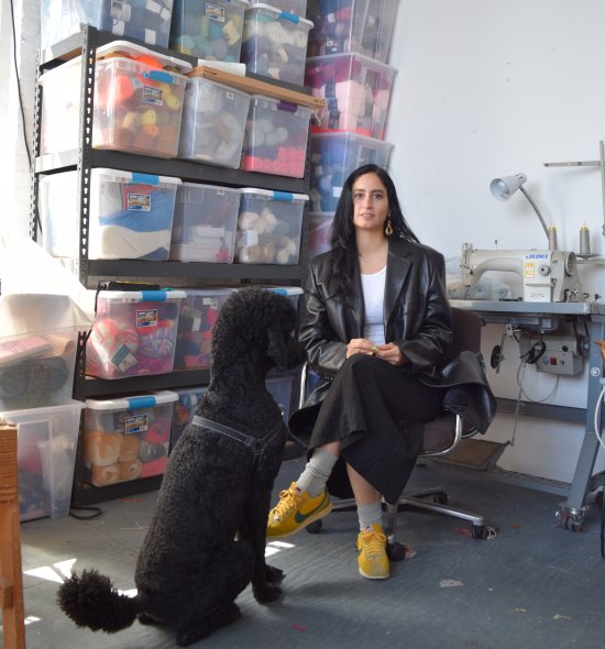 A person in a studio with a black poodle