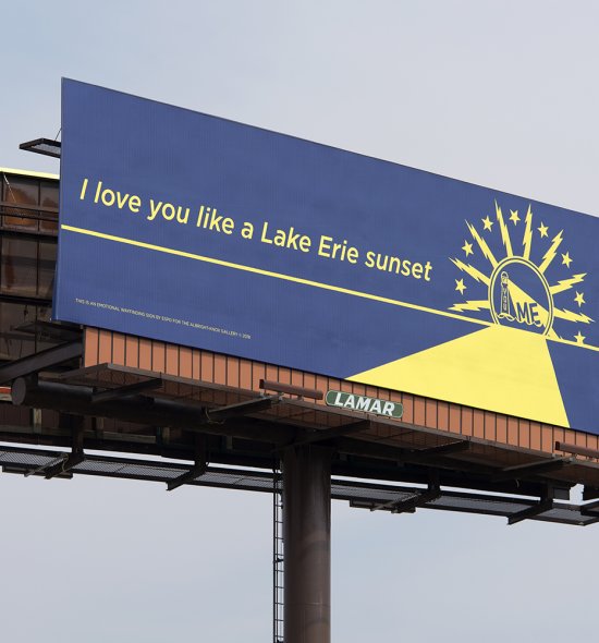A large blue billboard with yellow letters that say "I love you like a Lake Erie sunset"