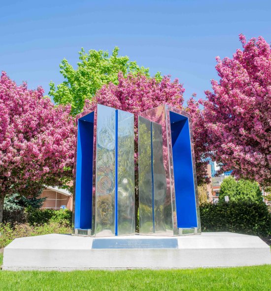 A sculpture composed of two rectangular shapes meeting at their corners - the outsides are mirrored chrome and the insides are matte blue