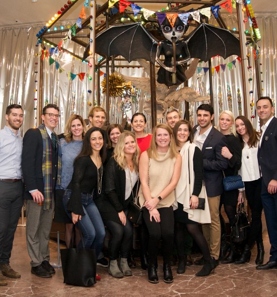 Group photo of people in front of a carousel