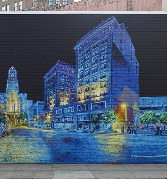 A large mural featuring icons of Buffalo architecture and people, dominated by blues, greens, and yellows