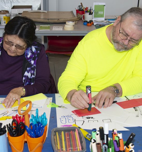 A woman and a man making art in a classroom